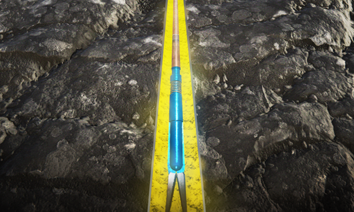 A farming tool with a blue handle and forked end is shown lying in a yellow-lined furrow on a soil field.