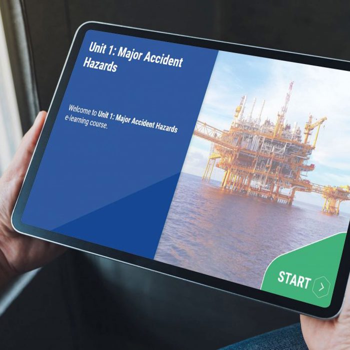 Person holding a tablet displaying an e-learning course titled "Unit 1: Major Accident Hazards" with an image of an offshore oil platform and a "Start" button.