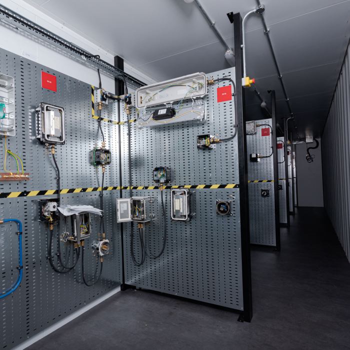 A corridor with industrial control panels and wiring on the walls in a technical facility.
