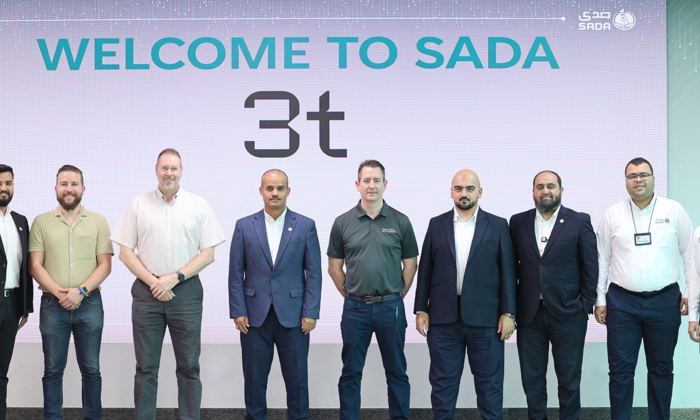 A group of eight men stands proudly in front of a sign that says "Welcome to SADA 3t," ready to embark on an exciting training journey.