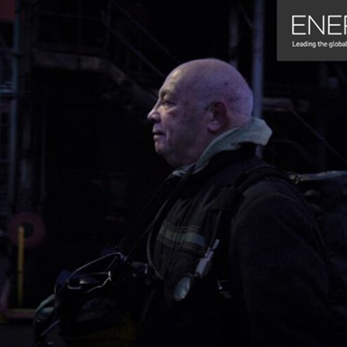 A person in work gear stands in a dark industrial setting. The image is accompanied by the "Energy Voice" logo and tagline: "Leading the global energy conversation.